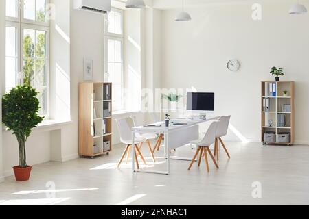 Intérieur d'un bureau d'affaires blanc moderne. Salle de conférence spacieuse et lumineuse et vide dans le bureau avec bureau, chaises et ordinateur pour les réunions ou les appels en ligne Banque D'Images