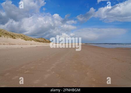 Des nuages gris se déplacent à travers la vaste étendue de la plage de Druridge Bay en Northumbrie depuis l'intérieur des terres Banque D'Images