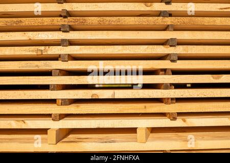 Stockage de piles de bois sur la scierie. Les planches sont empilées dans une boutique de menuiserie. Sciage séchage et commercialisation du bois. Bois de pin pour Banque D'Images