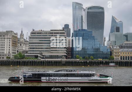 Uber Boat sur la Tamise passe devant les gratte-ciels de la ville de Londres et les immeubles de bureaux au bord de la rivière, mai 2021 Banque D'Images