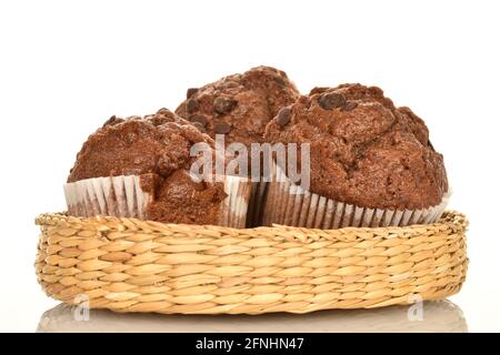 Plusieurs délicieux muffins au chocolat sur une assiette de paille, gros plan, sur fond blanc. Banque D'Images