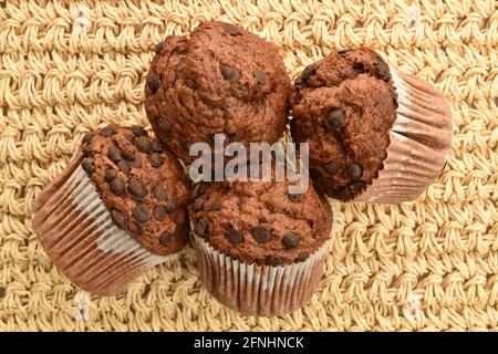 Quelques muffins au chocolat, gros plan, sur un tapis de paille, vue de dessus. Banque D'Images