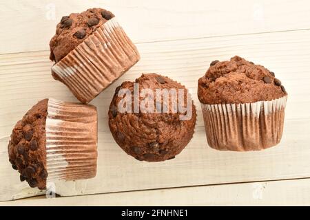 Plusieurs muffins au chocolat, gros plan, sur une table en bois blanc, vue du dessus. Banque D'Images