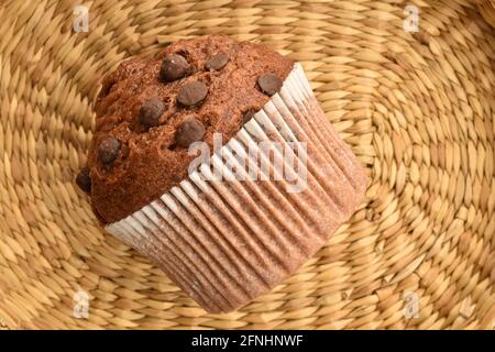 Un muffin au chocolat sur un tapis de paille, vue du dessus. Banque D'Images