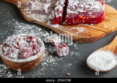 Un délicieux délice turc maison aux fruits, aux couleurs vives de rouge rose et aux noisettes. Le sucre des Confetted Confectioners est ajouté Banque D'Images