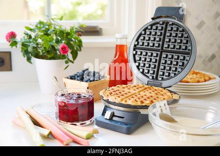 Sauce petit-déjeuner aux bleuets et rhubarbe avec gaufres en fer à gaufré Banque D'Images