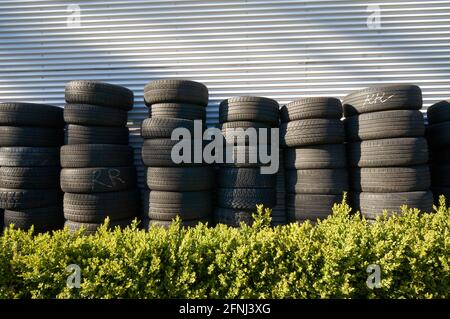 Des piles de pneus de voitures et de camions d'occasion en dehors d'une automobile garage de service Banque D'Images