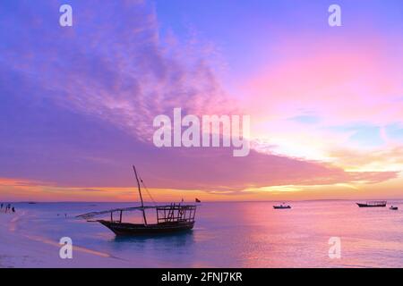 Coucher de soleil sur Zanzibar. Authentique bateau africain en bois sur la pittoresque rive de l'océan Banque D'Images