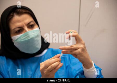 Téhéran, Iran. 17 mai 2021. Le personnel médical iranien portant un masque facial de protection charge une seringue avec le vaccin de la nouvelle maladie du coronavirus Sinopharm (COVID-19) dans le complexe commercial d'Iranmall au nord-ouest de Téhéran . (Photo de Sobhan Farajvan/Pacific Press) crédit: Pacific Press Media production Corp./Alay Live News Banque D'Images