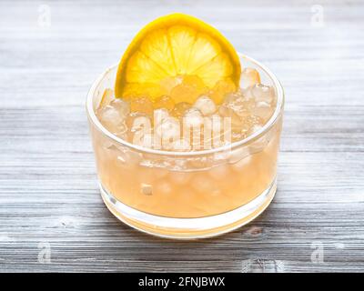 boules de tapioca bouillies avec une tranche de citron dans un bol en verre table en bois gris Banque D'Images