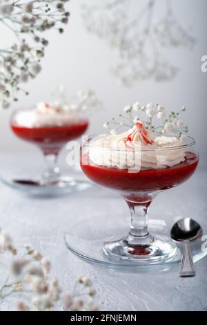 Dessert framboise-fraise avec crème au fromage dans de la verrine sur un gris arrière-plan Banque D'Images