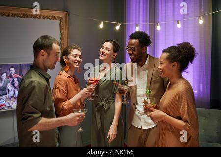 Portrait de taille vers le haut de divers groupes d'amis riant et discuter tout en profitant de la fête à la maison Banque D'Images
