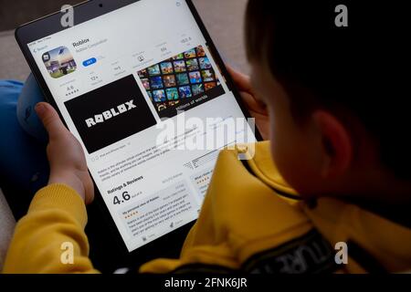 Application ROBLOX vue sur l'écran de l'ipad qui est entre les mains d'un enfant méconnaissable. Concept. Stafford, Royaume-Uni, 18 mai 2021. Banque D'Images