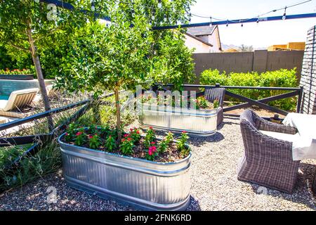 Deux bacs métalliques utilisés comme semoirs dans la cour arrière Banque D'Images