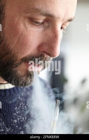 homme vaporant du distillat de cannabis avec un stylo de vape Banque D'Images