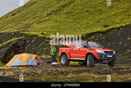 couple campant à côté de leur camion de ramassage modifié Islande Banque D'Images