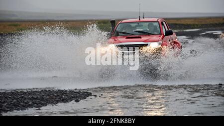 Camionnette modifiée traversant la rivière sur les hauts plateaux islandais Banque D'Images