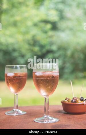 2 verres d'une boisson rose en verres avec olives à côté Banque D'Images