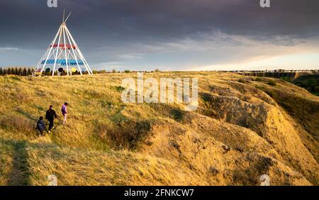 Medicine Hat Alberta Canada, mai 13 2021 : une famille marche à l'extérieur le long d'un sentier de randonnée dans Seven Persons Coulee, près de la Sammis Tepee au coucher du soleil. Banque D'Images