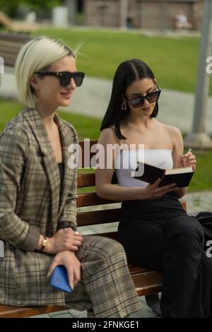 Deux femmes d'affaires sont en train de penser aux nouveaux plans pendant sur d'eux est l'écriture vers le bas Banque D'Images