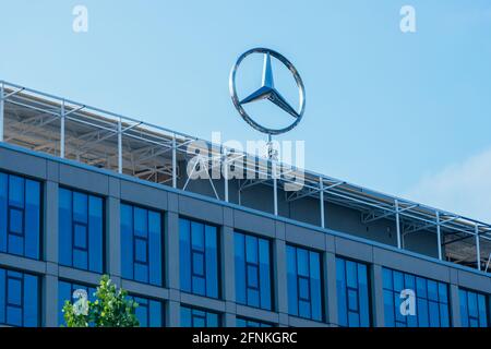 Logo Mercedes-Benz à trois étoiles pointues sur le dessus d'un bâtiment Banque D'Images