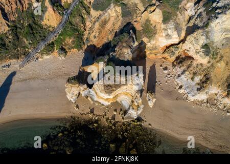 Plage de Camilo à Lagos, Algarve - Portugal. Falaises de la côte dorée sud portugaise. Vue aérienne au lever du soleil. Trou dans la vue de dessus de falaise. Banque D'Images