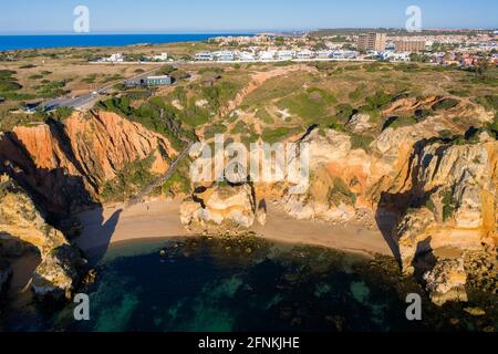 Plage de Camilo au lever du soleil. Lagos, Algarve - Portugal. Falaises de la côte dorée sud portugaise. Vue aérienne de jour ensoleillé. Mer turquoise. Bateau. Banque D'Images