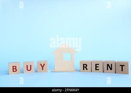 Achat ou location de maison concept. Modèle de maison en bois avec mot d'achat ou de location sur des blocs de bois. Banque D'Images