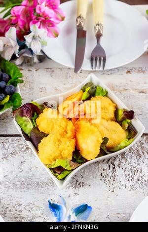 Crevettes panées frites avec salade verte et table. Banque D'Images