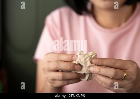 Mains de femme tenant le papier de soie usagé. Concept pour la saison de la grippe. Banque D'Images