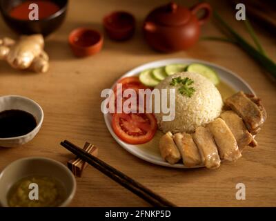 Riz au poulet Hainanese (riz au poulet cuit à la vapeur) avec sauces et légumes, cuisine asiatique traditionnelle Banque D'Images