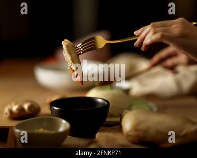 Vue rapprochée de la femme qui mange du poulet dans la sauce Chili, du riz au poulet Hainanese (riz au poulet à la vapeur), de la cuisine asiatique traditionnelle Banque D'Images