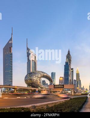 Vue panoramique de Sheikh Zayed Road montrant le nouveau monument du musée du futur ainsi que les gratte-ciel de Dubaï pendant l'heure bleue. Banque D'Images