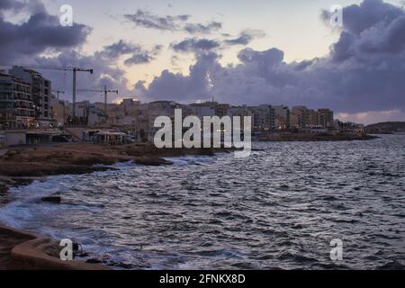 Rivage avec bâtiments et lumières pendant une nuit d'automne dans la baie de Saint-Paul, Malte. Banque D'Images