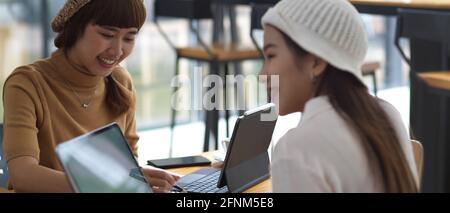 Portrait de deux étudiantes effectuant une affectation de groupe avec tablette numérique Banque D'Images