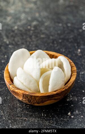 Croustilles en-cas blanches soufflées. Croustilles blanches sur table noire. Banque D'Images