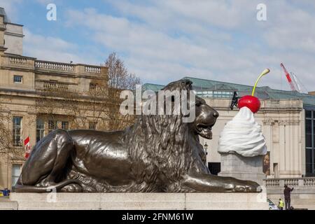 Lion de bronze à la place Trafalgar devant une œuvre géante de glace sur la quatrième plinthe, avec un drone qui représente une mouche sur la glace Banque D'Images