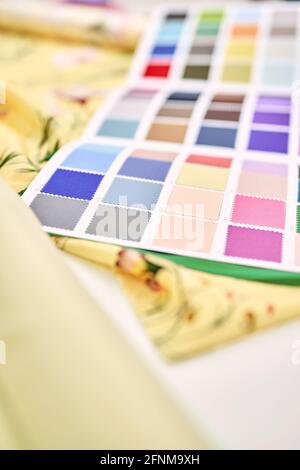 Concept sur mesure, atelier ou couturière. Catalogue de la palette d'échantillons de tissus colorés et tissus jaunes couchés sur une table. Photo verticale de haute qualité Banque D'Images