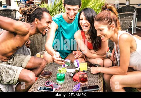 Amis multiraciaux s'amuser avec un smartphone mobile à la plage Bar à cocktails - les jeunes sont accros au smartphone Banque D'Images