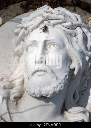 Statue de Jésus-Christ avec ses yeux tournés vers son front où se trouve une mouche. Banque D'Images