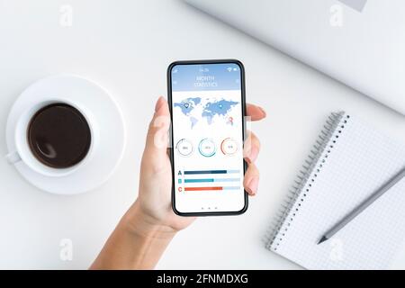 Vue de dessus du smartphone de la main féminine, à l'aide de l'application d'analyse Banque D'Images