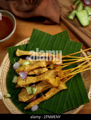 Satay de porc grillé (Moo Satay) avec concombre et oignon servi avec une sauce aux arachides, cuisine de rue asiatique Banque D'Images