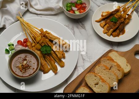Satay de porc grillé (Moo Satay) au concombre et à l'oignon servis avec de la sauce aux arachides et grillés pain Banque D'Images