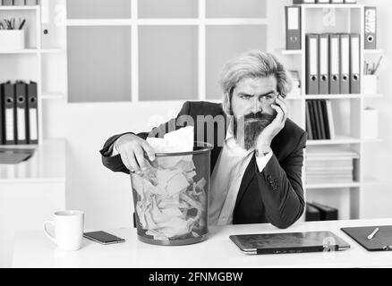 besoin de le trouver. homme d'affaires tient le trashcan. homme au bureau recherche la note perdue dans la corbeille à papier. papier froissé dans la corbeille à papier. homme lit un morceau de Banque D'Images