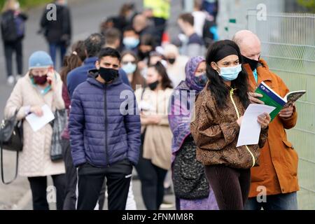 Les personnes faisant la queue pour la vaccination contre Covid à l'ESSA academy de Bolton comme la propagation de la variante du coronavirus indien pourrait conduire au retour des blocages locaux, ont reconnu les ministres. Bolton, Blackburn, Darwen et Bedford sont les domaines qui préoccupent le plus les ministres. Date de la photo: Mardi 18 mai 2021. Banque D'Images