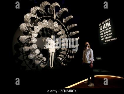 Un employé du Musée Victoria et Albert se tient devant la robe « Infinity » d'Herpen et Howe et la sculpture « Omniverse » exposées à l'exposition Alice : Curiouser et Curiouser au Musée Victoria et Albert de Londres. Date de la photo: Mardi 18 mai 2021. Banque D'Images