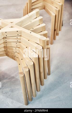 Piles de nouvelles bases en bois avec des jambes simples pour un style élégant les chaises sont assemblées dans une cabine de peinture légère lors de la clôture de l'atelier Banque D'Images