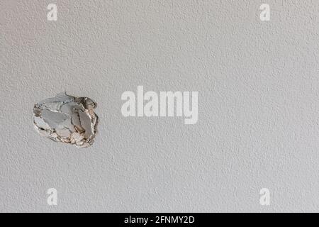 Un trou dans le mur d'un couloir causé par un poing qui frappe le mur Banque D'Images