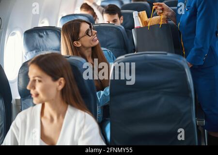 Heureusement qu'un passager passe son bagage à main au préposé à la réception Banque D'Images