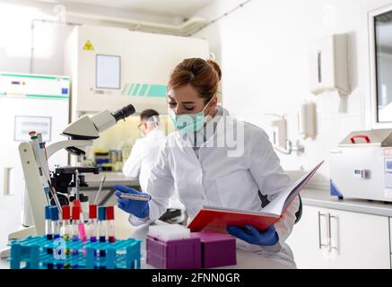 Deux biologistes, homme et femme, travaillent sur des échantillons en laboratoire Banque D'Images